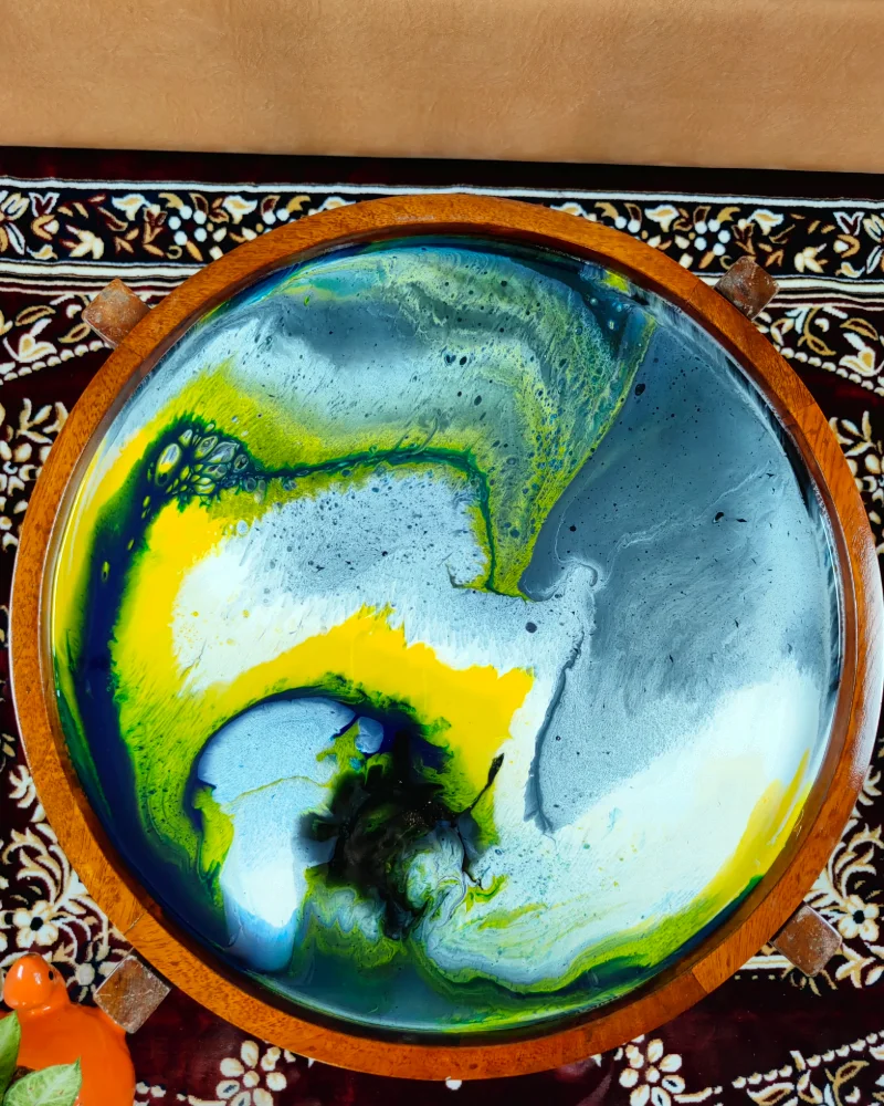 Coloured epoxy resin poured and swirled in a round tray